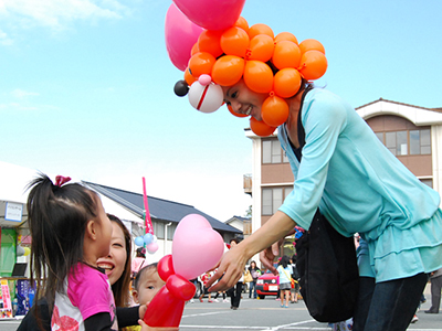 子どもにバルーンを渡すお姉さん